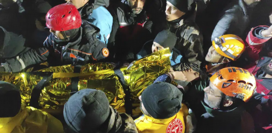 Rescatistas y médicos trasladan a una joven que fue rescatada de entre los escombros de un edificio derruido en Sanliurfa, en el sur de Turquía, el 6 de febrero de 2023, luego de un potente sismo. (IHA via AP)