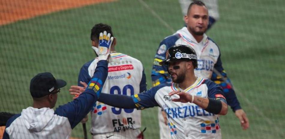 Integrantes del equipo de Venezuela celebran luego de anotar una de las carreras que realizó en el triunfo sobre Curazao.