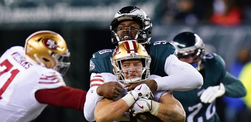 Christian McCaffrey (23) de San Francisco es tacleado por el defensive end Robert Quinn de los Eagles en el campeonato de la Conferencia Nacional de la NFL.