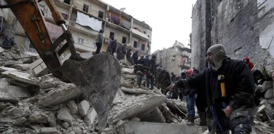 Trabajadores de la Defensa Civil y fuerzas de seguridad buscan entre los escombros de edificios derrumbados, el lunes pasado, en Alepo, Siria  AP