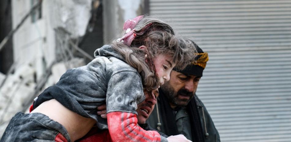 Residentes sacan a un niño herido de los escombros de un edificio derrumbado. Fuente: AFP.