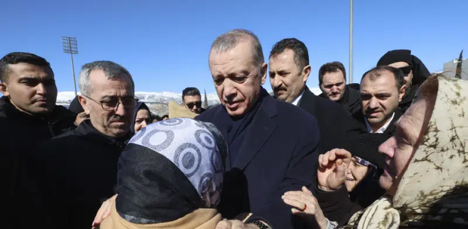 En esta imagen de archivo, el presidente de Turquía, Recep Tayyip Erdogan, habla con una sobreviviente durante una visita al centro de la ciudad de Kahramanmaras, destruido por un potente sismo, en el sur de Turquía, el 8 de febrero de 2023. (Presidencia de Turquía vía AP, archivo)