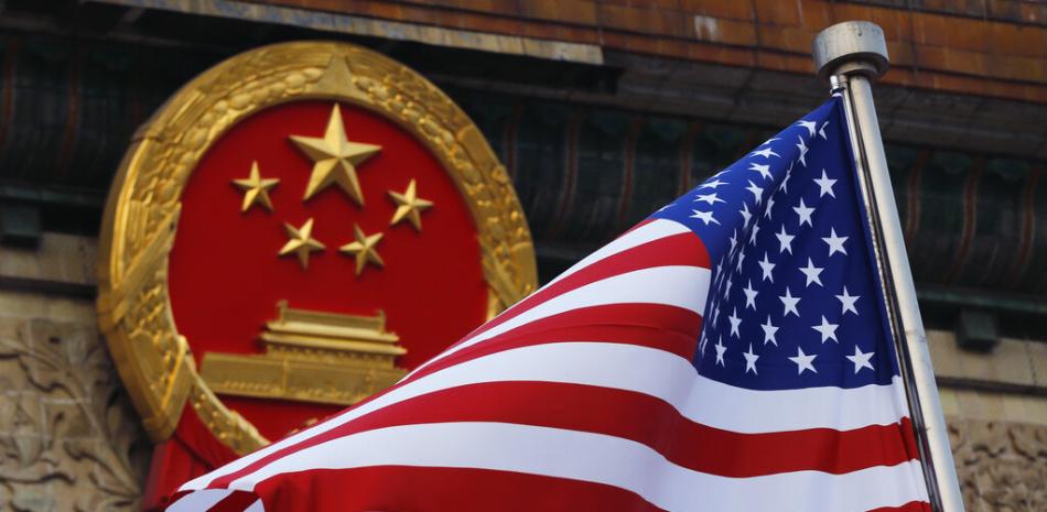 Una bandera estadounidense ondea junto al emblema nacional chino durante una ceremonia de bienvenida en el Gran Salón del Pueblo, en Beijing. AP