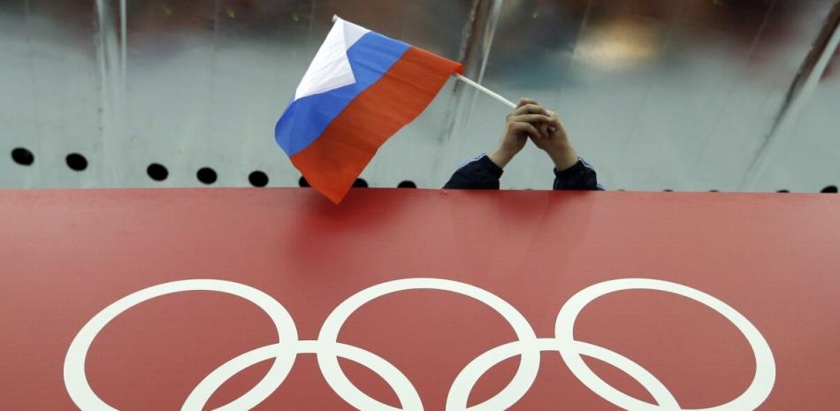 Una bandera rusa es desplegada encima de los anillos olímpicos durante los Juegos de Invierno en Sochi, Rusia, el 18 de febrero de 2014.