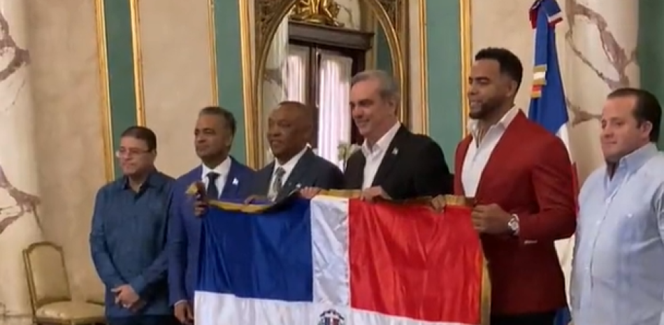 El presidente, Luis Abinader, entrega el símbolo patrio a directivos y varios jugadores. Captura de video.