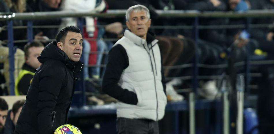 El técnico del Barcelona Xavi Hernández (izquierda) da instrucciones durante el partido contra el Villarreal por la Liga española, el domingo 12 de febrero de 2023.