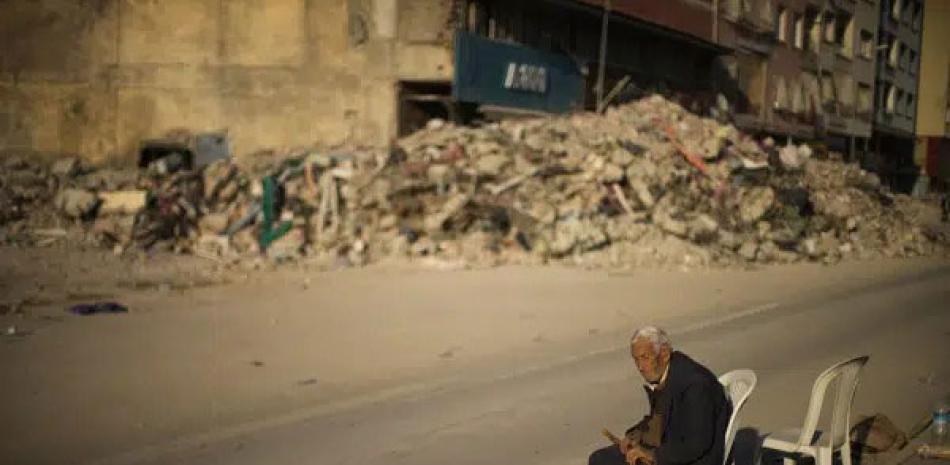 Un hombre se sienta en una silla junto a los escombros de un edificio derruido en la ciudad de Alejandreta, en el sur de Turquía, ayer martes. AP