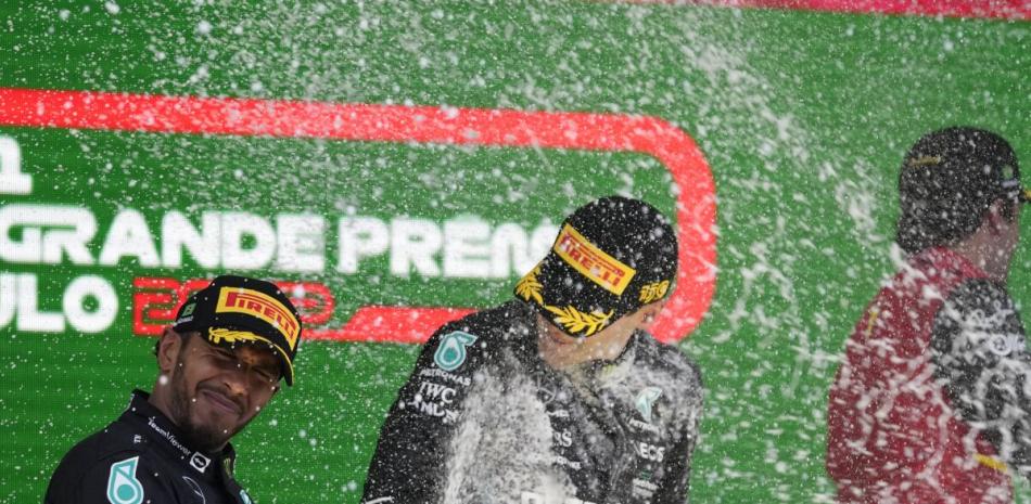 El piloto de Mercedes Lewis Hamilton lanza champaña a su compañero de equipo George Russell en el podio del Gran Premio de Brasil, el 13 de noviembre de 2022.
