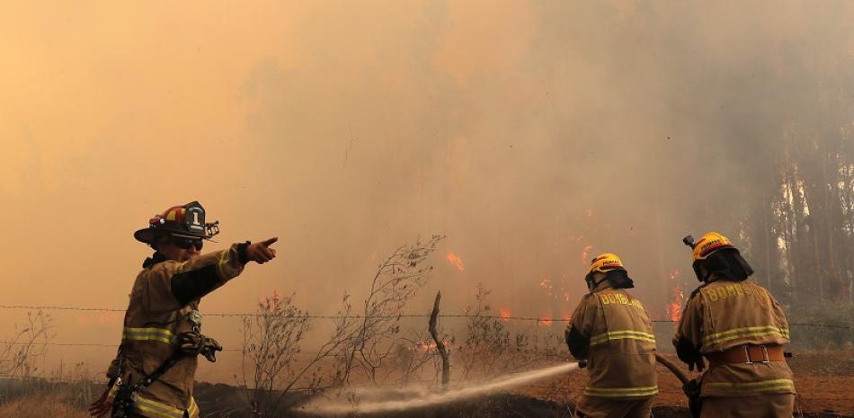 Bomberos intentando apagar los fuertes incendios en Chile. Foto: AFP