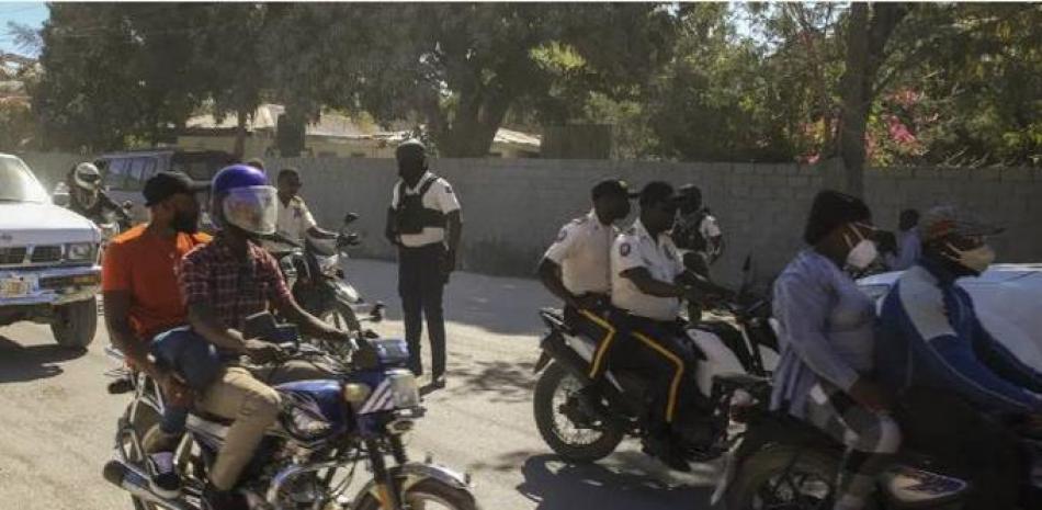 Un grupo de policías junto con otros residentes en Puerto Príncipe el 10 de febrero de 2023. (Foto AP /Odelyn Joseph)