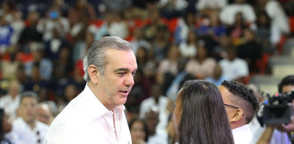 El presidente Luis Abinader comparte con una pareja de jóvenes graduados.