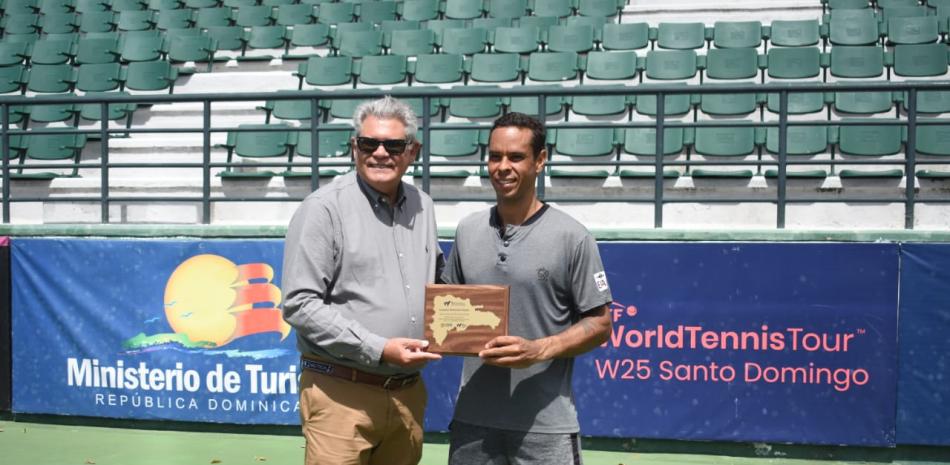 Sergio Tobal, director del torneo, premia a Daniel Dutra da Silva, campeón del M25 Santo Domingo.