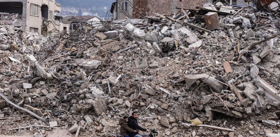 Un hombre conduce su motocicleta frente a edificios derrumbados en la ciudad de Antakya el 19 de febrero de 2023. Un terremoto de magnitud 7,8 golpeó cerca de Gaziantep, Turquía, en las primeras horas del 6 de febrero, seguido de otro temblor de magnitud 7,5 poco después del mediodía.
Foto: Sameer Al-Doumy/ AFP
