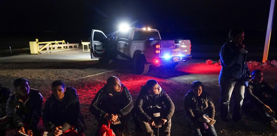 Varios migrantes esperan ser procesados por las autoridades estadounidenses luego de cruzar la frontera de Estados Unidos con México, el 6 de enero de 2023, cerca de Yuma, Arizona. (AP Foto/Gregory Bull, Archivo)