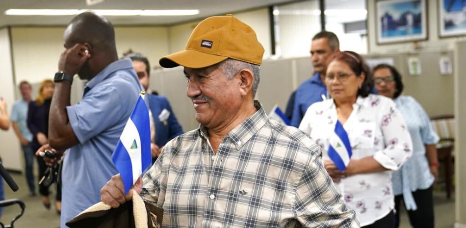 Víctor Manuel Sosa Herrera sostiene una bandera nicaragüense cuando llega con otros presos políticos recientemente liberados de Nicaragua, para una conferencia de prensa en la oficina de la alcaldesa del condado de Miami-Dade, Daniella Levine-Cava, el miércoles 15 de febrero de 2023 en Miami.