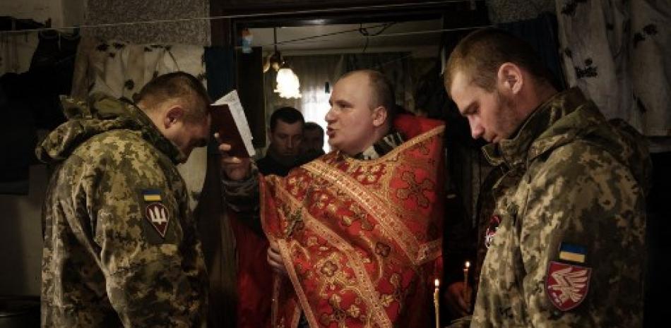 Mykola Berezyk, conocido como "padre Mykola", dirige una oración en una casa de la región de Donetsk (Ucrania), el 22 de febrero de 2023. AFP