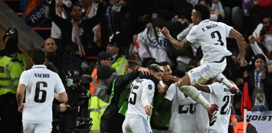 El delantero francés del Real Madrid, Karim Benzema, es acosado por sus compañeros de equipo después de marcar el quinto gol del equipo durante el partido de ida de los octavos de final de la Liga de Campeones de la UEFA entre Liverpool y Real Madrid en Anfield en Liverpool, noroeste de Inglaterra, el 21 de febrero de 2023.
Pablo ELLIS / AFP