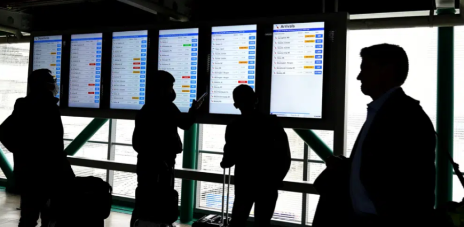 Los viajeros consultan las pantallas de información de vuelo de American Airlines para conocer el estado de su vuelo en el Aeropuerto Internacional O'Hare en Chicago, el miércoles 22 de febrero de 2023. (Foto AP/Nam Y. Huh)