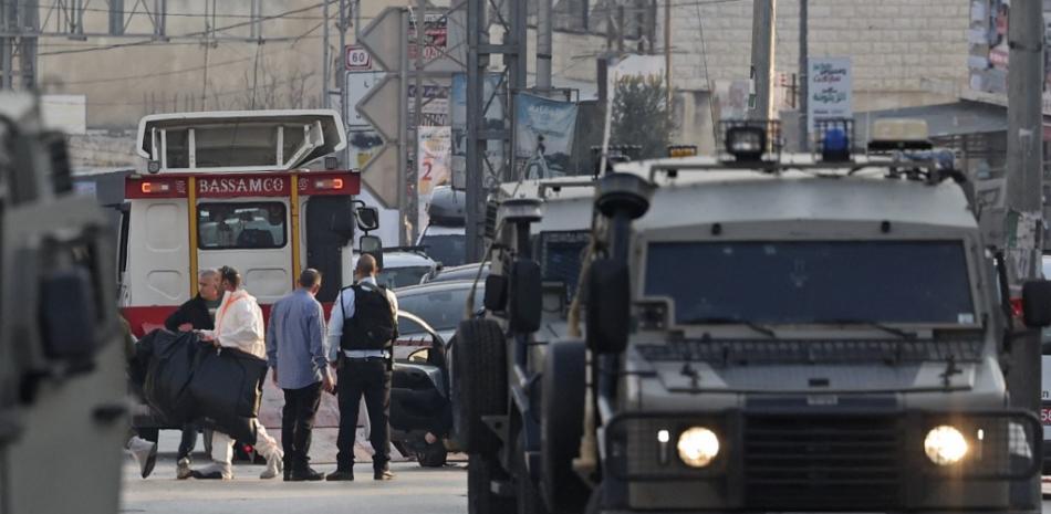 Las fuerzas de seguridad israelíes bloquean una carretera mientras el personal de emergencia trabaja en el lugar de un atentado en el que murieron dos israelíes en la localidad de Hawara, en la Cisjordania ocupada, el 26 de febrero de 2023. Foto: Ahmad Gharabali/AFP.