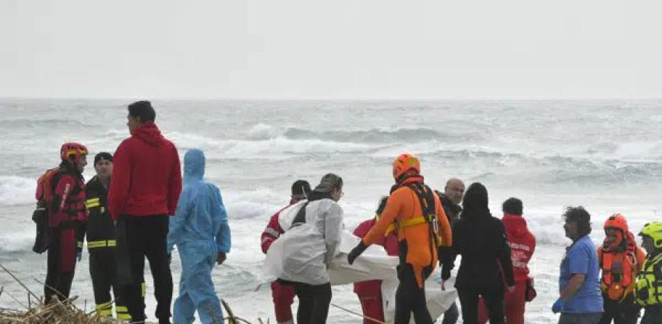 Rescatistas recuperan un cadáver en una playa cercana a Cutro, tras el hundimiento de un bote en  Italia. ap