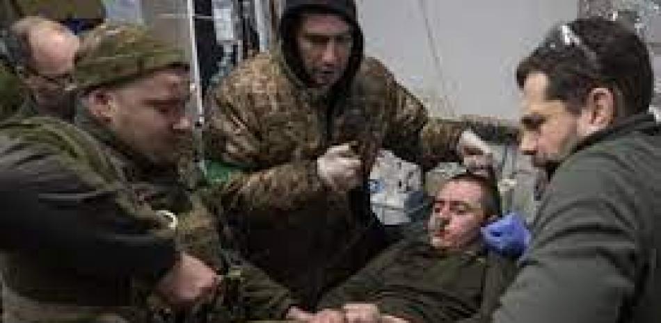 Médicos militares ucranianos atienden a un soldado que llegó del campo de batalla, el domingo 26 de febrero de 2023, cerca de Bájmut, Ucrania. Foto: AP.