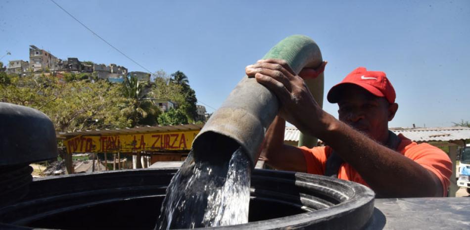 Un hombre almacena agua en un tanque para el uso cotidiano de familias residentes en el sector. Jorge Martínez/LD
