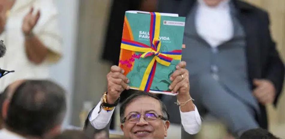 El presidente colombiano Gustavo Petro enseña la propuesta para reformar el sistema de salud antes de presentarlo al Congreso en un acto en el palacio presidencial de Nariño en Bogotá, Colombia, el lunes 13 de febrero de 2023. AP