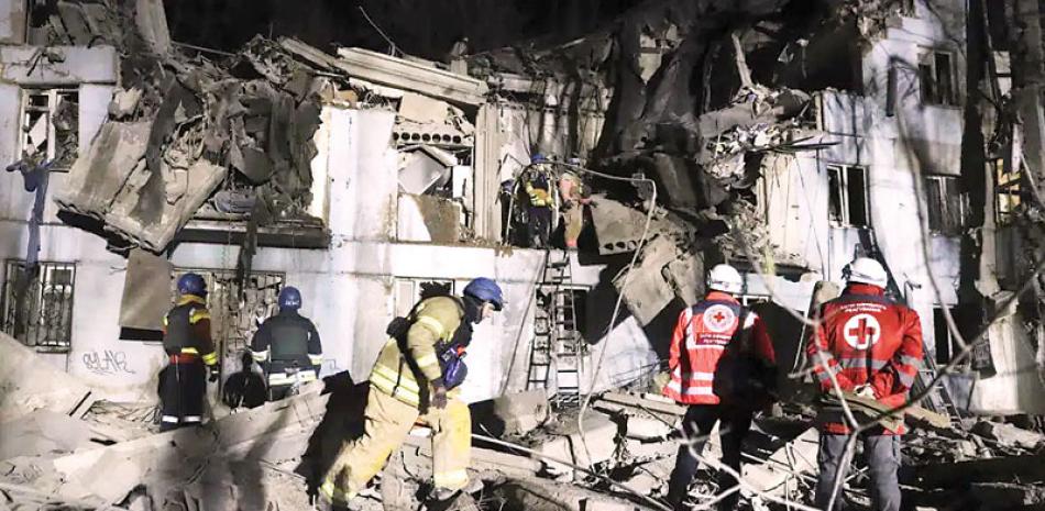 Bomberos de los servicios de emergencias ucranianos inspeccionan una vivienda dañada tras un bombardeo ruso, en Zaporiyia, Ucrania, el 2 de marzo de 2023.  AP