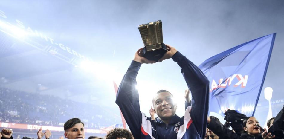 Kylian Mbappé, delantero del París Saint-Germain, alza el trofeo que lo acredita como máximo goleador en la historia del equipo.