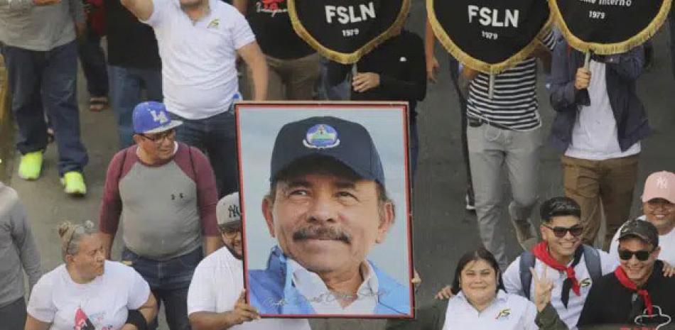 Un hombre marcha con un retrato del presidente Daniel Ortega durante una marcha progubernamental en Managua, Nicaragua, el sábado 11 de febrero de 2023. AP