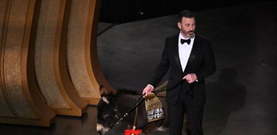 El presentador de televisión Jimmy Kimmel sube al escenario con un burro durante la 95ª Entrega Anual de los Premios de la Academia en el Dolby Theatre de Hollywood, California, el 12 de marzo de 2023. Patrick T. Fallon / AFP