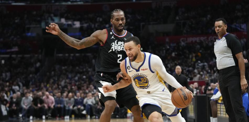 Kawhi Leonard, de los Clippers, defiende a Stephen Curry, de los Warriors, durante el partido del miércoles en el baloncesto de la NBA.