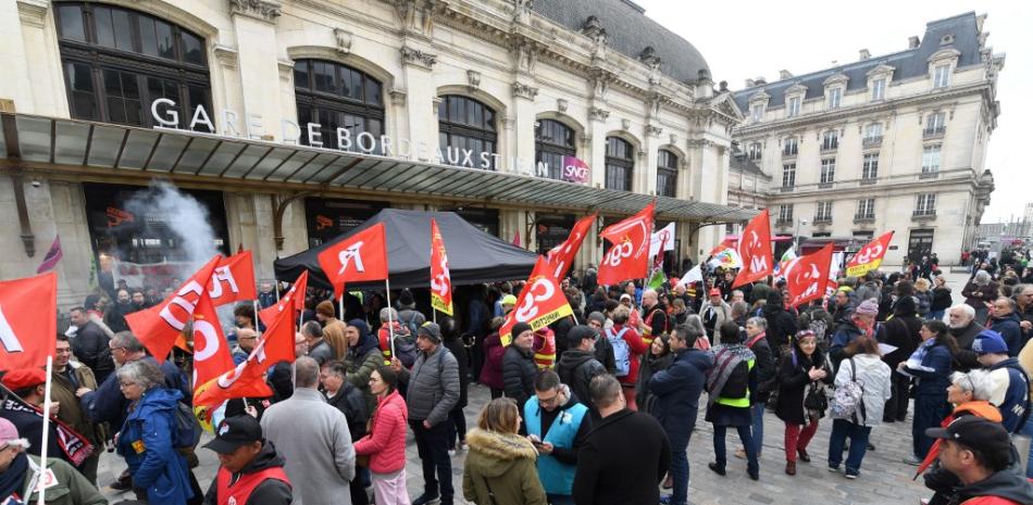 Sindicalistas del sector ferroviario y manifestantes se manifiestan frente a la estación de tren, un día después de que el gobierno francés impulsara una reforma de las pensiones en el parlamento sin votación, utilizando el artículo 49.3 de la constitución, en Burdeos, suroeste de Francia, el 17 de marzo de 2023