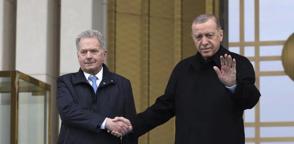 El presidente turco Recep Tayyip Erdogan, derecha, y su homólogo finlandés Sauli Niinisto estrechan manos durante una ceremonia de bienvenida en el Palacio Presidencial en Ankara, Turquía, el viernes 17 de marzo de 2023. (AP Foto/Burhan Ozbilici)