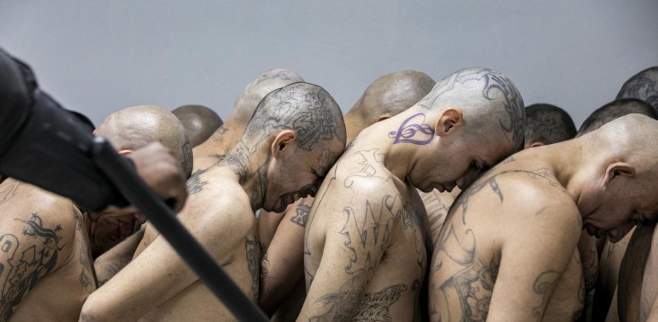 En esta foto difundida por la oficina de prensa presidencial de El Salvador, reclusos considerados por las autoridades como miembros de pandillas son trasladados a la mega prisión del Centro de Confinamiento del Terrorismo, en Tecoluca, El Salvador, el miércoles 15 de marzo de 2023. (Oficina de prensa presidencial de El Salvador vía AP)