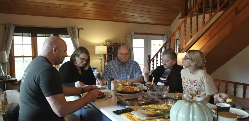 Doug Whitney (centro) desayuna con su familia en Manson, Washington, el 5 de noviembre de 2022. Whitney heredó la misma mutación genética que hizo que le diera alzhéimer a su madre, hermano y otros parientes durante varias generaciones, a la edad inusualmente joven de 50 años. Doug tiene 73 años y aún tiene una mente aguda. De alguna manera, evadió su destino genético. (AP Foto/Shelby Lum