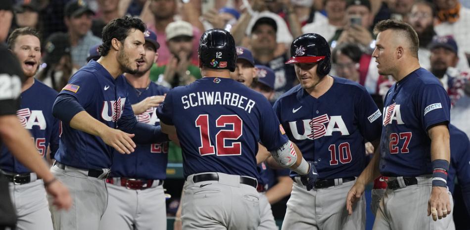 El equipo de EE. UU. felicita a Kyle Schwarber (12) luego de conectar un jonrón durante la octava entrada de un juego final del Clásico Mundial de Béisbol contra Japón, el martes 21 de marzo de 2023, en Miami. Japón derrotó a Estados Unidos 3-2.