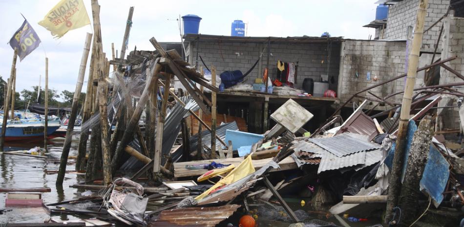 Casa derrumbada sobre el agua tras un terremoto que sacudió la costa de Ecuador, en el poblado de Puerto Bolívar, Ecuador, el domingo 19 de marzo de 2023. (Foto AP/César Muñoz)