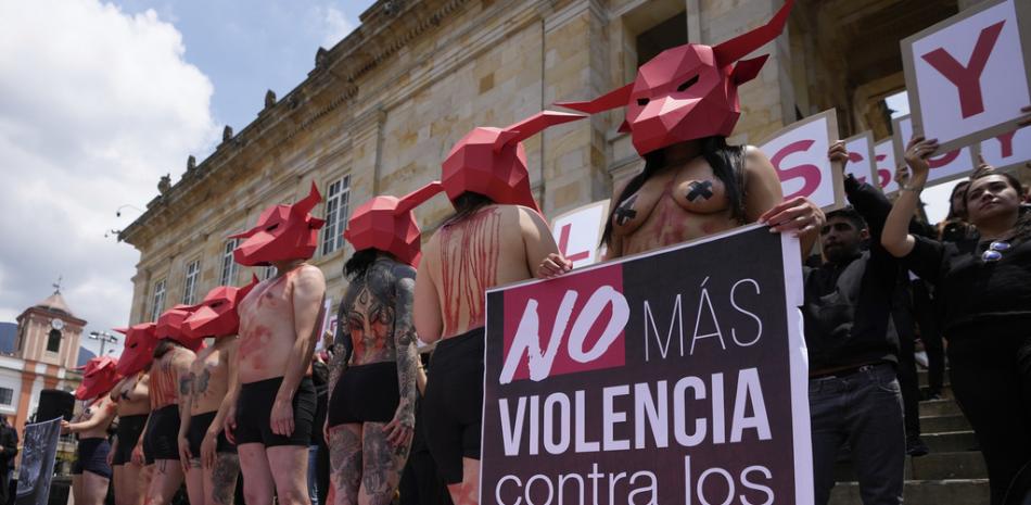 Activistas por los derechos de los animales protestan contra las corridas de toros frente al Congreso con un cartel que dice en español "No más violencia contra los animales" en Bogotá, Colombia, el martes 28 de marzo de 2023. AP