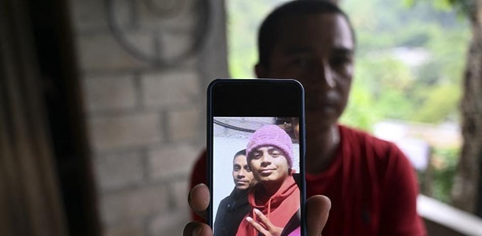 Emmanuel Tzina muestra una foto de sus primos, los migrantes guatemaltecos Francisco Rojche (derecha) y Miguel Rojche, quienes murieron en un centro de detención de inmigrantes mexicanos durante un incendio, en el pueblo de Las Siete Vueltas, Chicacao, Guatemala, el 3 de abril de 2023. AFP