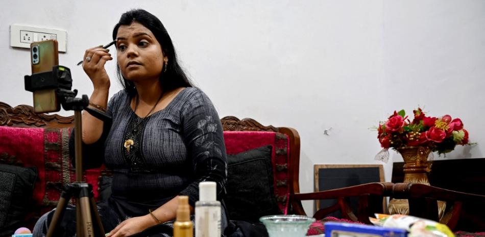 En esta foto tomada el 11 de marzo de 2023, la influencer de maquillaje de las redes sociales Kavita Jadon, de 34 años, hace videos tutoriales con su teléfono en su casa en Bulandshahr, Uttar Pradesh. 

Foto: Arun Sankar/ AFP