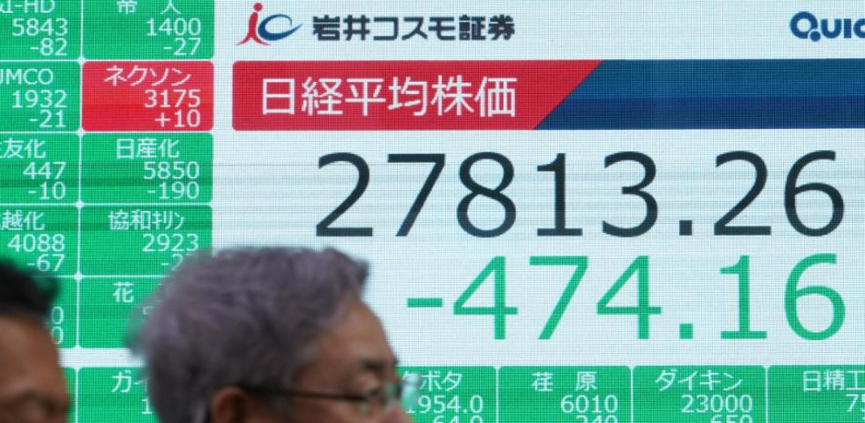 Los peatones pasan frente a un tablero electrónico de cotizaciones que muestra los números de cierre de los precios de las acciones de la Bolsa de Valores de Tokio en Tokio el 5 de abril de 2023.
Foto: Kazuhiro NOGI / AFP