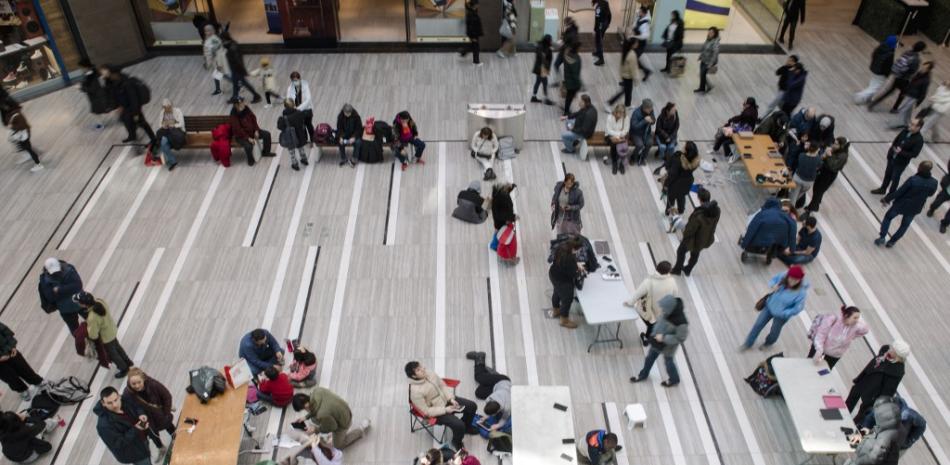 Las personas cargan sus teléfonos en las estaciones instaladas en el CF Fairview Mall el 7 de abril de 2023 en Montreal, Canadá, después de que la lluvia helada azotara partes de Quebec y Ontario el 5 de abril. 
Foto: ANDREJ IVANOV / AFP