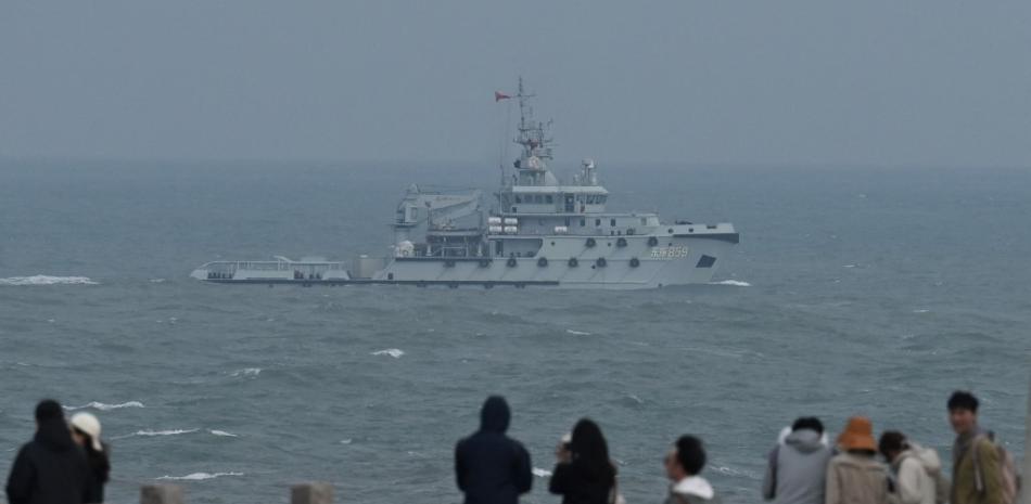 Un remolcador de la Armada del Ejército Popular de Liberación de China navega por el estrecho de Taiwán, pasando junto a los turistas de la isla de Pingtan, el punto más cercano a Taiwán, en la provincia suroriental china de Fujian, el 7 de abril de 2023. AFP.