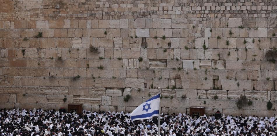El 9 de abril de 2023, en el Muro de las Lamentaciones, en la Ciudad Vieja de Jerusalén, unos hombres judíos, vestidos con el tradicional manto de oración judío, conocido como talit, participan en la oración de los cohanim (bendición de los sacerdotes) durante la festividad de la Pascua judía (Pésaj). Foto: Menahem Kahana/AFP.