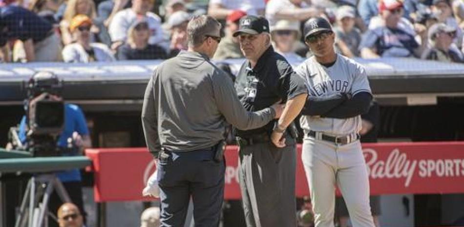 El umpire Larry Vanover es atendido por el médico de los Guardianes de Cleveland después de recibir un pelotazo en la cabeza durante la quinta entrada del juego de béisbol en Cleveland.