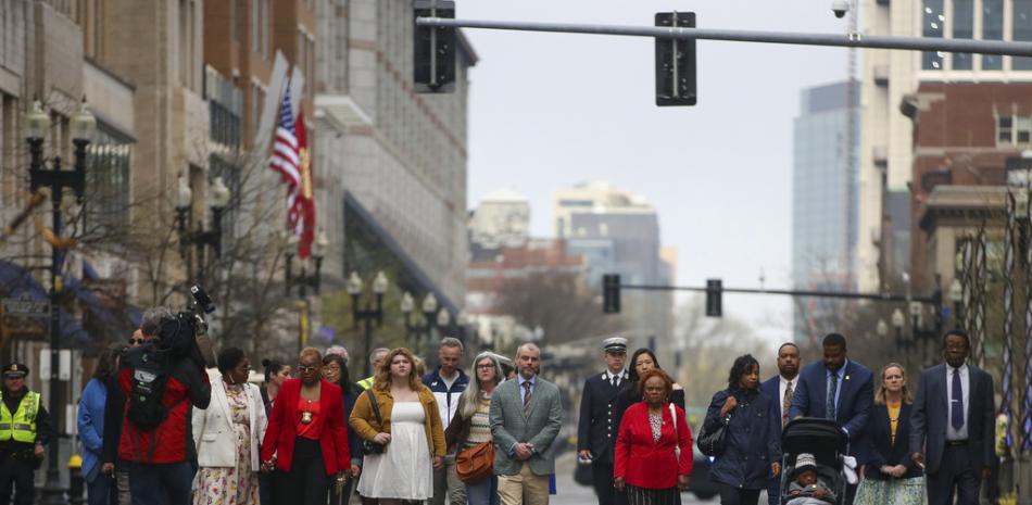 Participantes de una reunión para las víctimas del bombardeo del maratón de Boston de 2013 entre monumentos conmemorativos en Boylston Street, el sábado 15 de abril de 2023, en Boston. (Foto AP/Reba Saldanha)