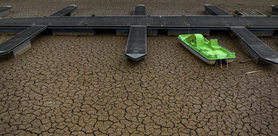 Un bote a pedales verde está amarrado a un muelle en una parte seca del embalse de Sau, a unos 100 km (62 millas) al norte de Barcelona, España, el martes 18 de abril de 2023. (Foto AP/Emilio Morenatti)