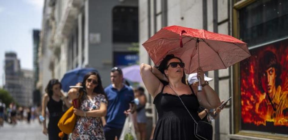 Una mujer sostiene un paraguas para protegerse del sol durante un caluroso día soleado en Madrid, España, el 18 de julio de 2022. Mirando hacia atrás al clima de 2022 con meses de análisis, la Organización Meteorológica Mundial dice que el año pasado realmente fue tan malo como parecía.