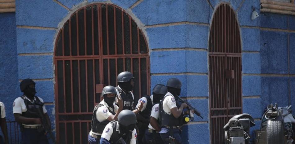Agentes de policía se refugian durante una operación antipandillas en el barrio de Lalue en Puerto Príncipe, Haití, el viernes 3 de marzo de 2023. (Foto AP/Odelyn Joseph)